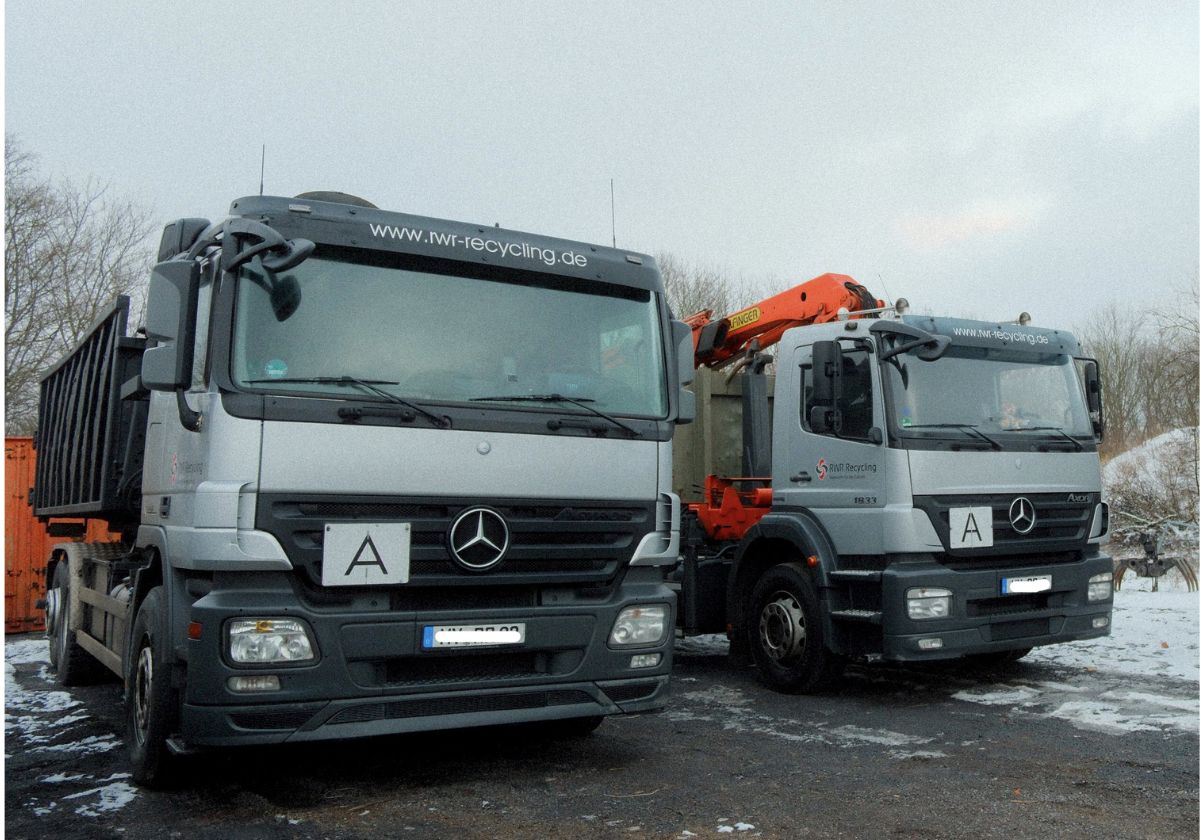 Silberner RWR Recycling-LKW mit Container steht für den professionellen Ankauf von Schrott und Metallen wie Kupfer, Edelstahl und Aluminium zu aktuellen Tagespreisen.